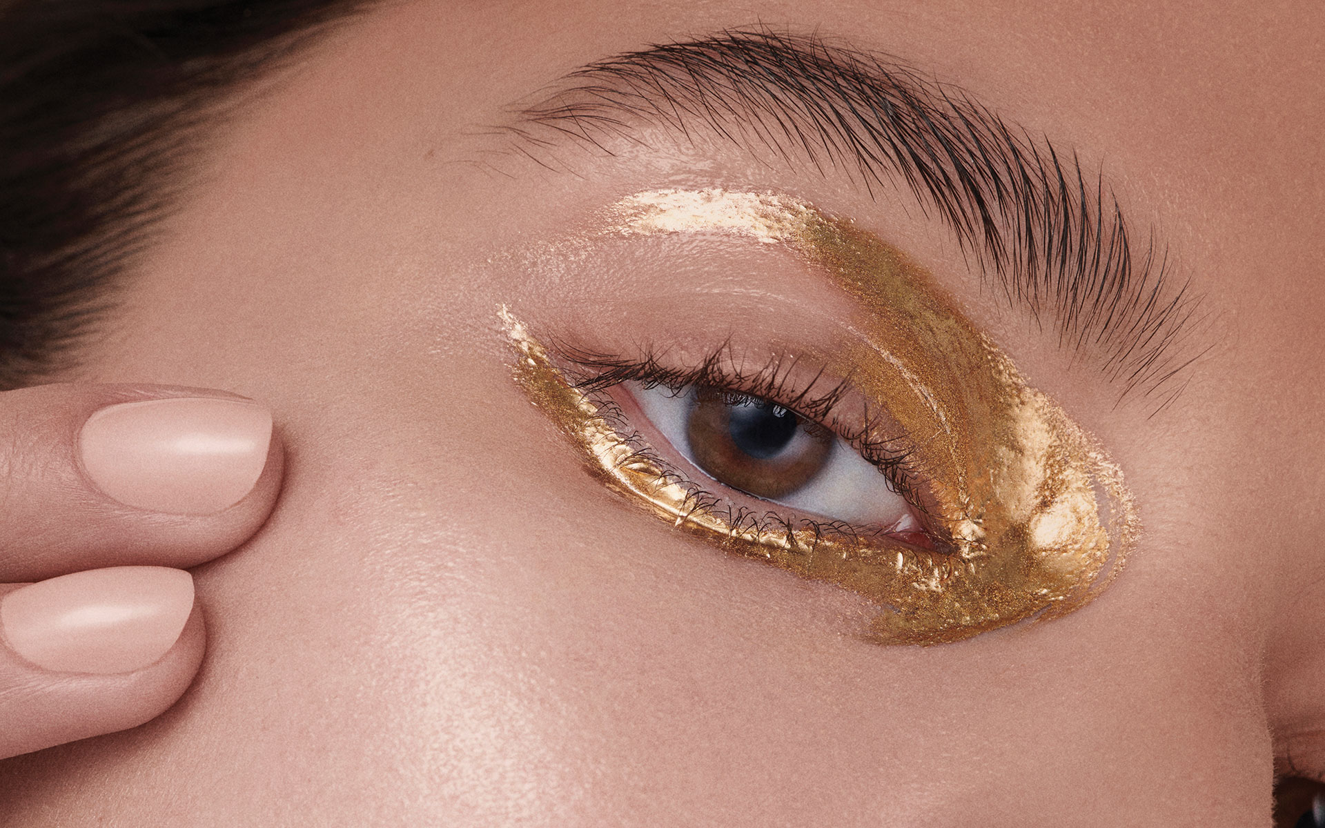a person with gold glitter around their eye