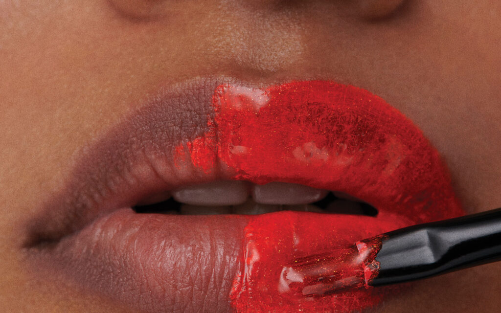 a person applying red lip stain